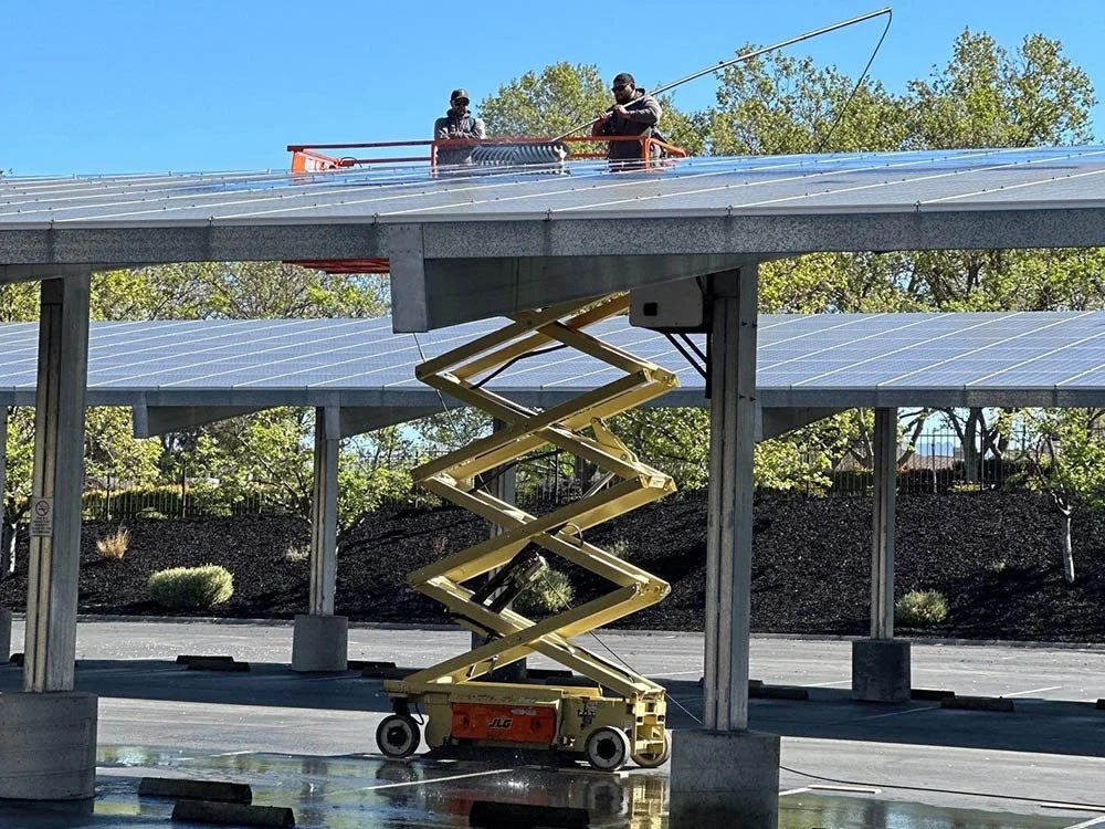 Commercial solar panel cleaning using scissor lift on large rooftop installation